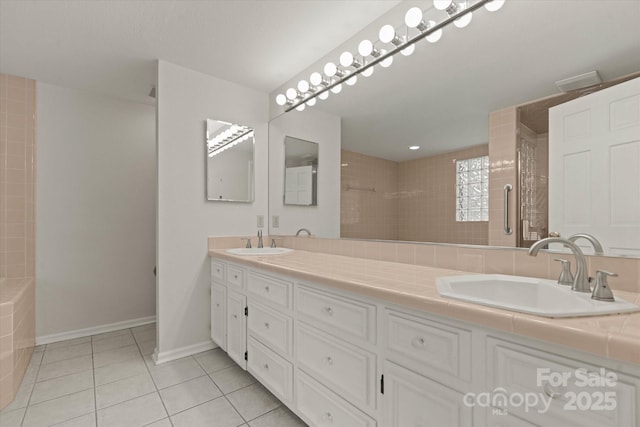 bathroom with a sink, tile patterned floors, double vanity, and tiled shower
