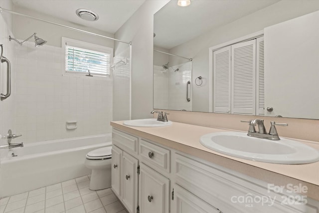 bathroom featuring toilet, tile patterned floors, a sink, and shower / bathing tub combination