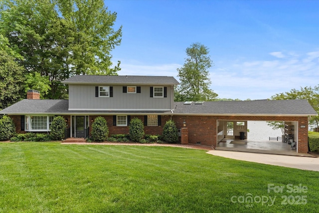 traditional home with a chimney, a front yard, and brick siding