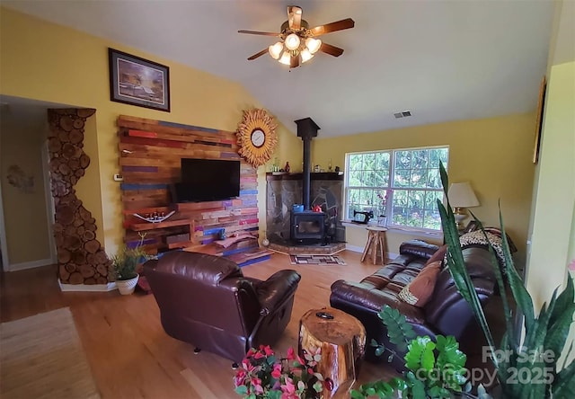 6454 Sain Milling Rd, Vale, NC 28168 - living area with a ceiling fan, visible vents, vaulted ceiling, a wood stove, and wood finished floors