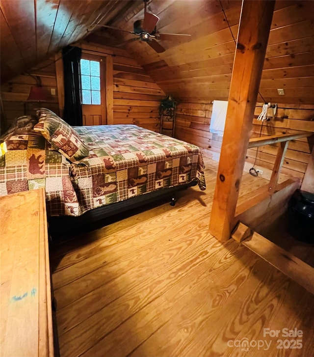 bedroom featuring wood ceiling, vaulted ceiling, wood walls, and wood finished floors