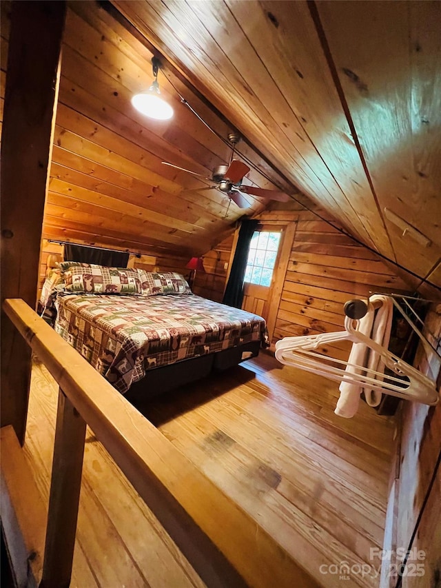 bedroom featuring wood walls, lofted ceiling, hardwood / wood-style floors, and wooden ceiling