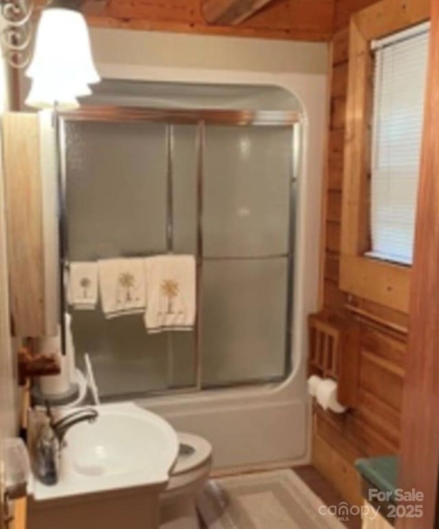 full bathroom featuring vanity, combined bath / shower with glass door, and toilet