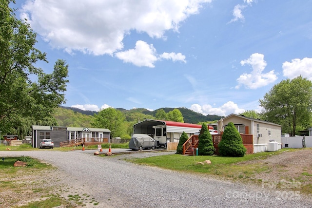 222 Pike Pt, Waynesville, NC 28785 - view of front of home featuring a detached carport, a deck with mountain view, and driveway