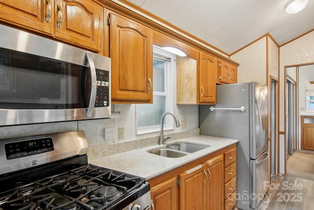 222 Pike Pt, Waynesville, NC 28785 - kitchen with appliances with stainless steel finishes, a sink, light countertops, brown cabinetry, and vaulted ceiling
