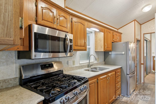222 Pike Pt, Waynesville, NC 28785 - kitchen featuring appliances with stainless steel finishes, a sink, light countertops, brown cabinetry, and backsplash