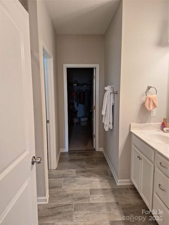 1202 Calder Dr, Indian Trail, NC 28079 - bathroom with a spacious closet, baseboards, and vanity