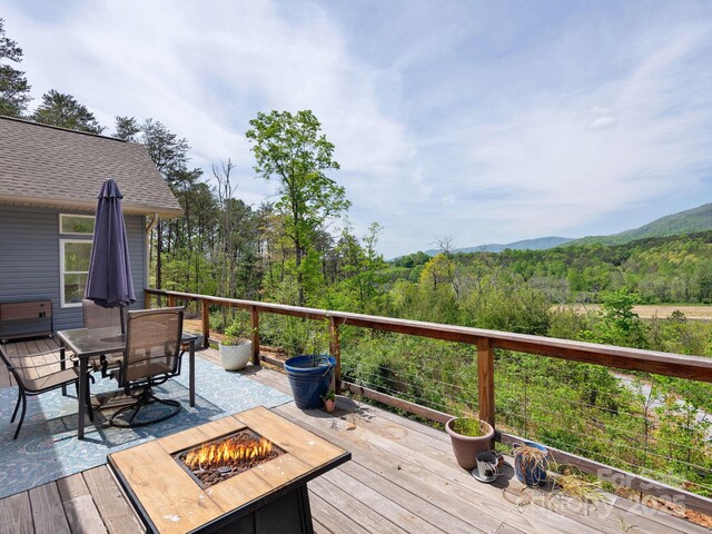 1810 Coopers Gap Rd, Mill Spring, NC 28756 - wooden deck with a view of trees, a mountain view, outdoor dining space, and an outdoor fire pit