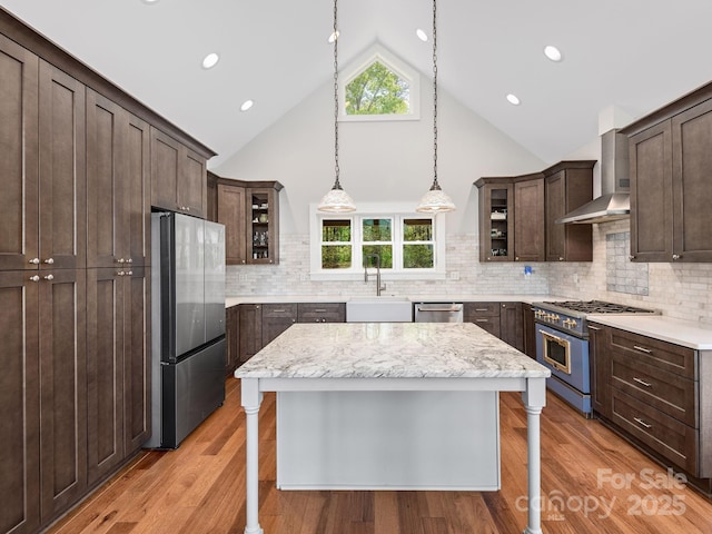 1810 Coopers Gap Rd, Mill Spring, NC 28756 - kitchen with dark brown cabinetry, a sink, glass insert cabinets, stainless steel appliances, and wall chimney exhaust hood