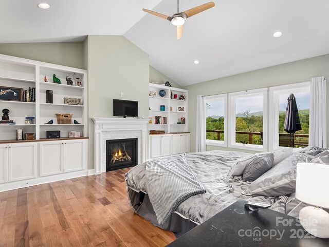 1810 Coopers Gap Rd, Mill Spring, NC 28756 - bedroom with a glass covered fireplace, lofted ceiling, light wood-type flooring, recessed lighting, and a ceiling fan