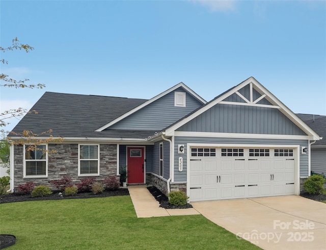 craftsman house with driveway, board and batten siding, stone siding, a front lawn, and a garage