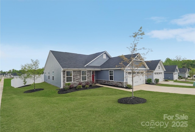 view of front of house featuring fence, a garage, driveway, stone siding, and a front lawn