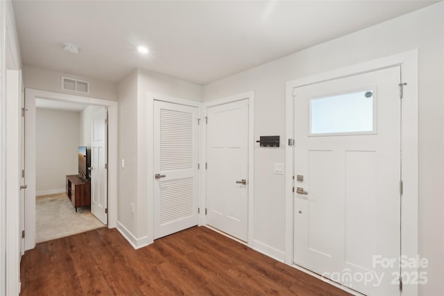 foyer with visible vents, dark wood-style floors, and baseboards