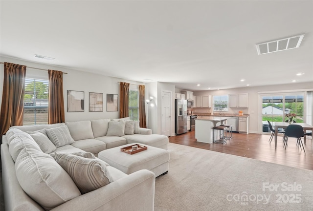 living area featuring visible vents, a wealth of natural light, and recessed lighting