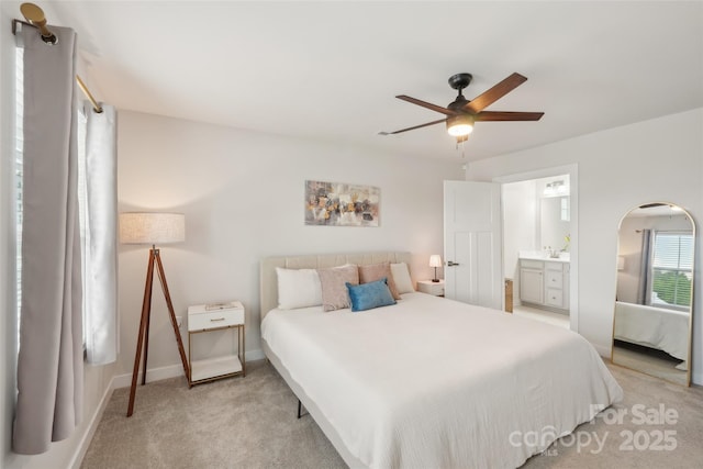 bedroom featuring arched walkways, light carpet, ceiling fan, ensuite bathroom, and baseboards