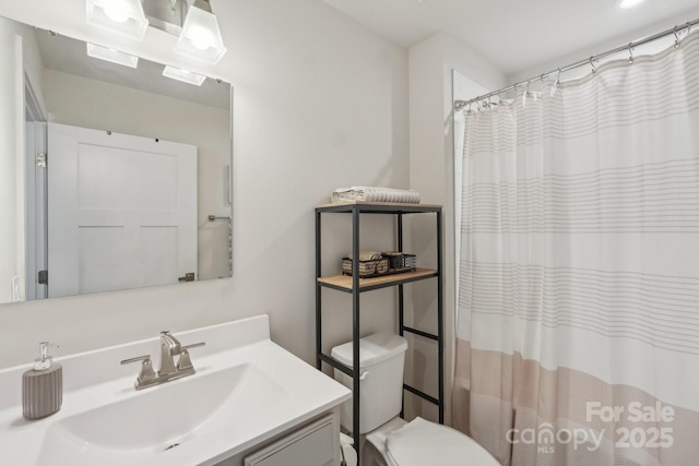 full bathroom featuring toilet, curtained shower, and vanity