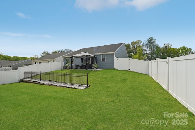view of yard featuring a gazebo, a gate, and a fenced backyard