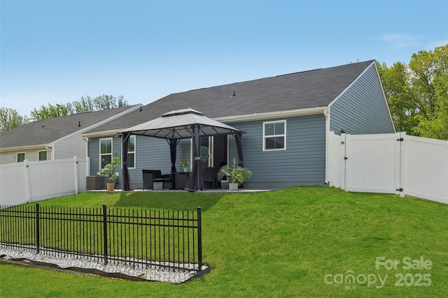 back of property featuring a lawn, a gazebo, a gate, and a fenced backyard