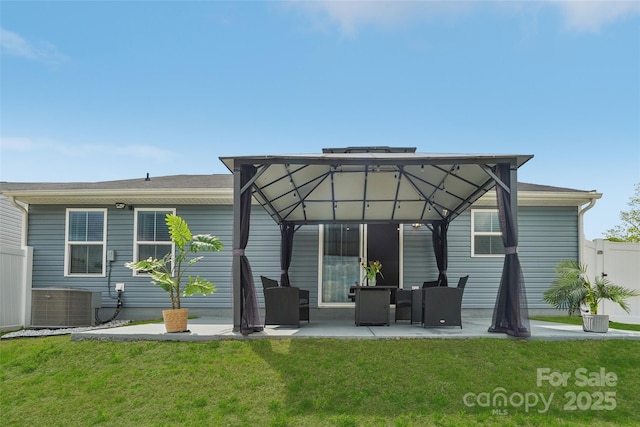 rear view of house featuring fence, cooling unit, a patio, a gazebo, and a lawn