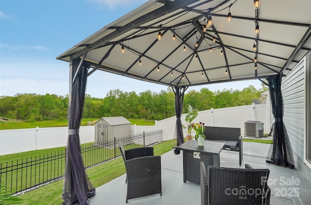 view of patio with central AC, a gazebo, a fenced backyard, and a shed