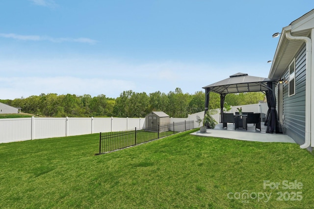 view of yard featuring a fenced backyard, an outdoor structure, a storage unit, a gazebo, and a patio