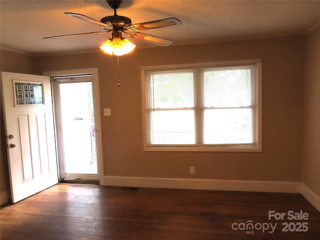 interior space featuring a textured ceiling, ceiling fan, wood finished floors, and baseboards