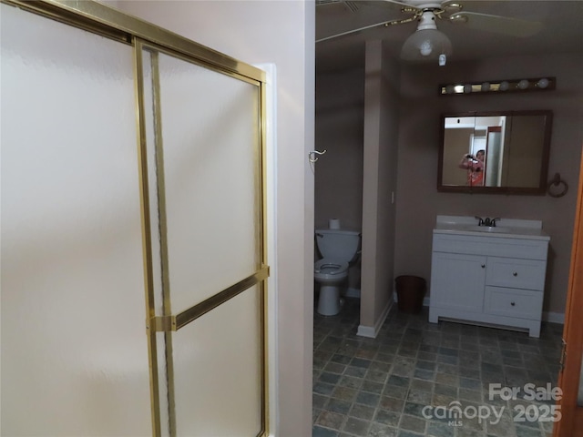 full bath featuring baseboards, a shower stall, a ceiling fan, and toilet