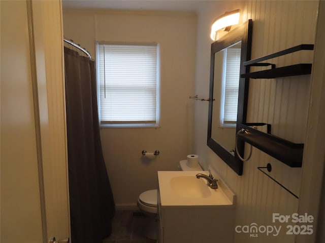 bathroom featuring a shower with shower curtain, a wealth of natural light, toilet, and vanity