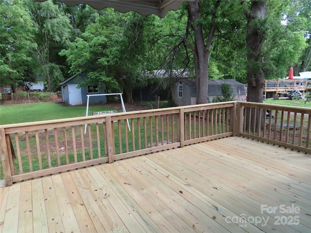 deck with an outbuilding, a lawn, and a storage shed