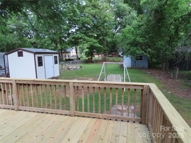 wooden deck with a storage unit, an outdoor structure, a fenced backyard, and a lawn