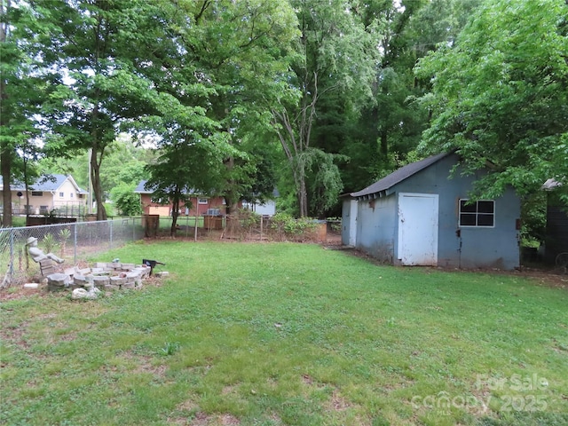 view of yard with fence and an outdoor structure