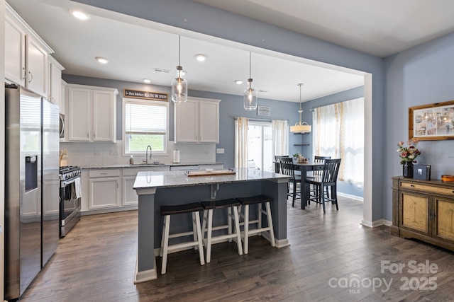 3828 Yorkshire Pl, Terrell, NC 28682 - kitchen featuring white cabinets, a center island, a sink, light stone countertops, and appliances with stainless steel finishes