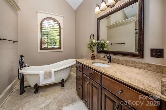 4600 Spicewood Dr, Charlotte, NC 28227 - full bathroom featuring baseboards, vaulted ceiling, a freestanding tub, and vanity