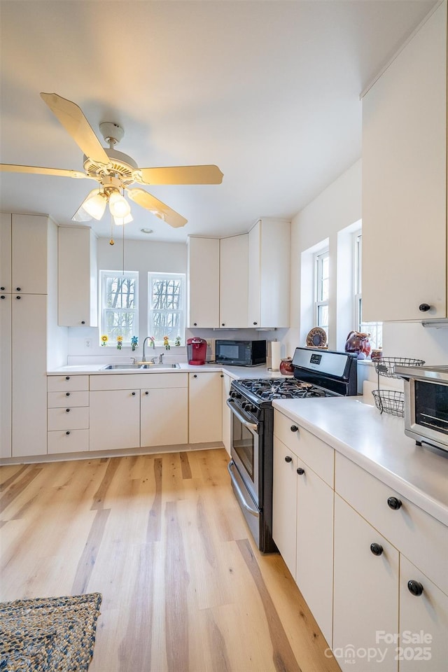 661 Old Chestnut Mountain Rd, Newland, NC 28657 - kitchen with gas range, plenty of natural light, black microwave, and light wood-type flooring