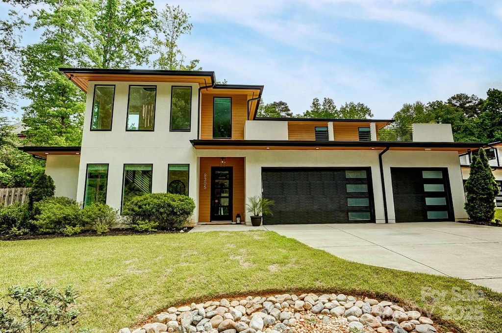 9305 Valley Rd, Charlotte, NC 28270 - modern home with a front lawn, a garage, concrete driveway, stucco siding, and fence