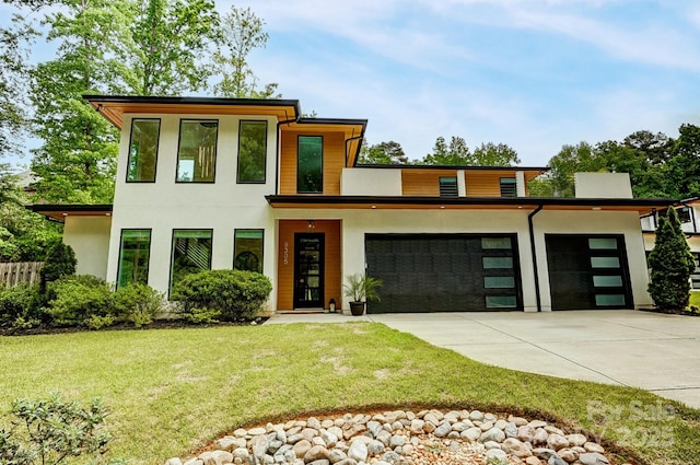 9305 Valley Rd, Charlotte, NC 28270 - modern home with a front lawn, a garage, concrete driveway, stucco siding, and fence