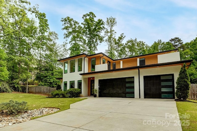 9305 Valley Rd, Charlotte, NC 28270 - contemporary home with driveway, stucco siding, fence, a front lawn, and a garage