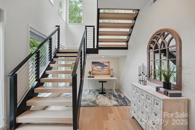 9305 Valley Rd, Charlotte, NC 28270 - stairs featuring a towering ceiling, visible vents, wood finished floors, and baseboards