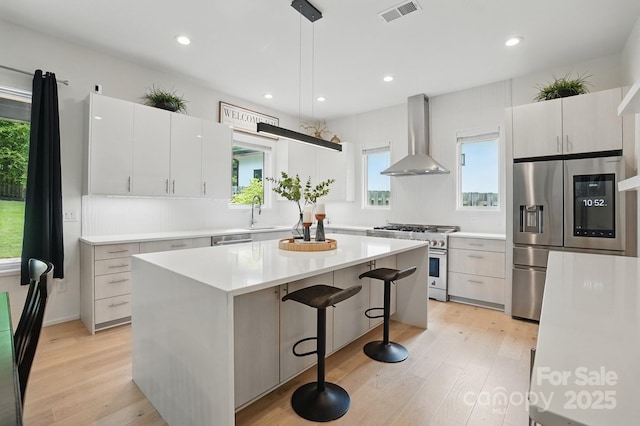 9305 Valley Rd, Charlotte, NC 28270 - kitchen featuring visible vents, stainless steel appliances, light countertops, a kitchen island, and wall chimney exhaust hood