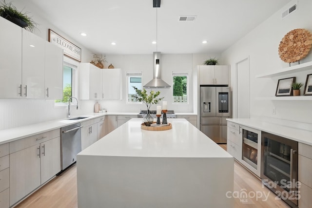 9305 Valley Rd, Charlotte, NC 28270 - kitchen with a sink, appliances with stainless steel finishes, wall chimney range hood, and visible vents