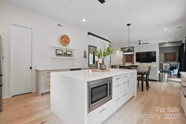 9305 Valley Rd, Charlotte, NC 28270 - kitchen featuring a center island, a ceiling fan, modern cabinets, and stainless steel microwave