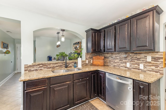 kitchen featuring backsplash, light tile patterned floors, a sink, and dishwasher