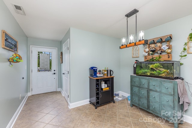 entrance foyer featuring baseboards, light tile patterned flooring, and visible vents