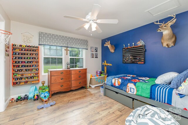 bedroom with attic access, ceiling fan, and wood finished floors