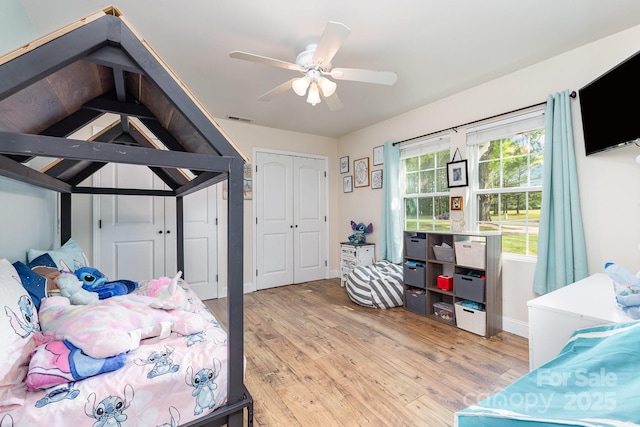 bedroom with baseboards, ceiling fan, light wood-style flooring, and visible vents