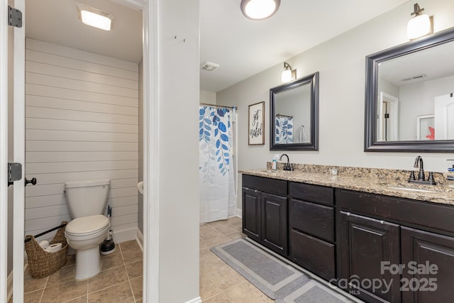 full bath featuring visible vents, a sink, double vanity, and toilet