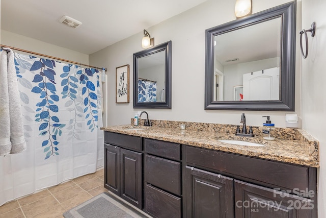 bathroom featuring a sink, tile patterned floors, double vanity, and visible vents