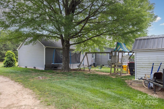 view of yard featuring a trampoline, a playground, and cooling unit