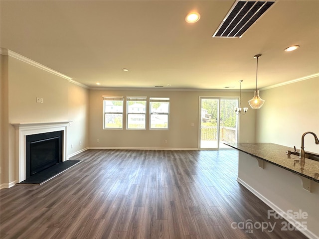 17121 Carolina Pine Row, Charlotte, NC 28278 - unfurnished living room featuring dark wood-style flooring, baseboards, visible vents, a fireplace with raised hearth, and ornamental molding