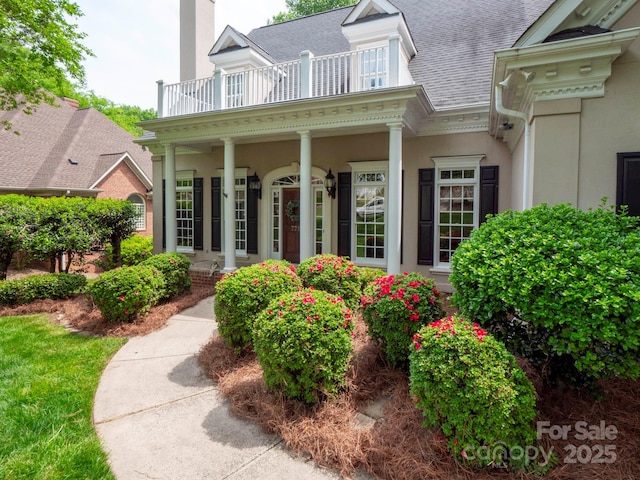 7716 Seton House Ln, Charlotte, NC 28277 - view of exterior entry with a balcony, a porch, roof with shingles, and stucco siding